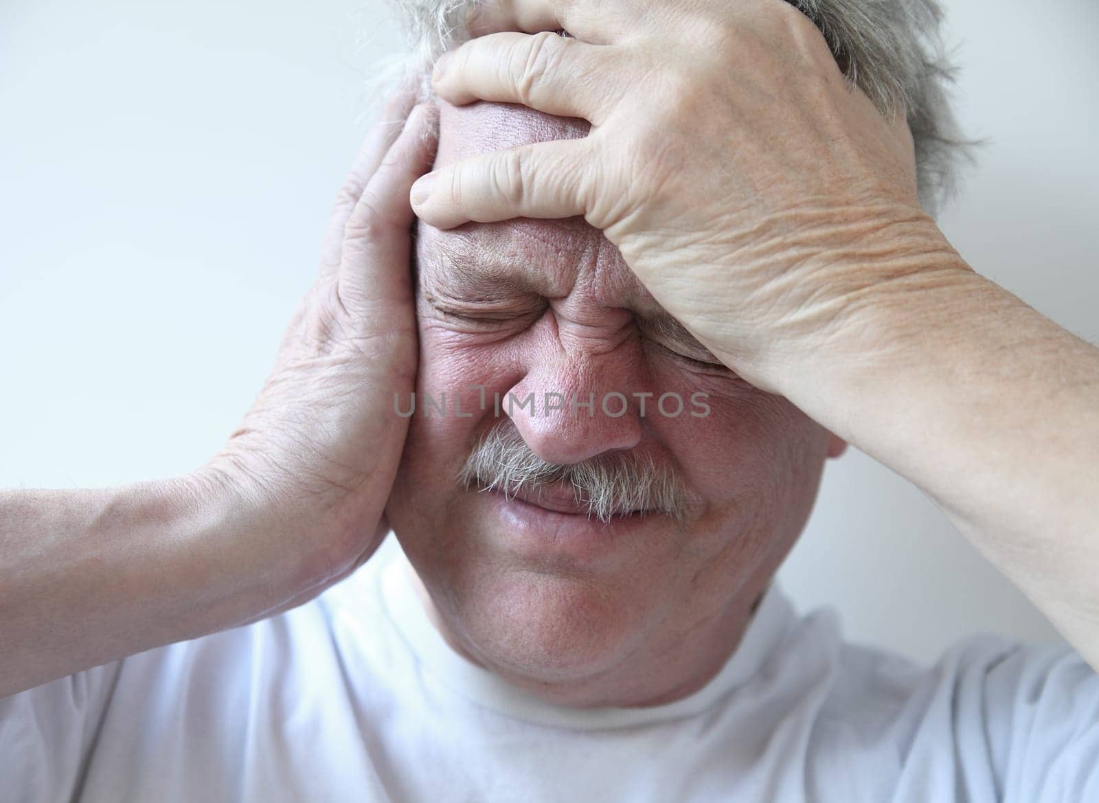 older man suffering from pounding head pain