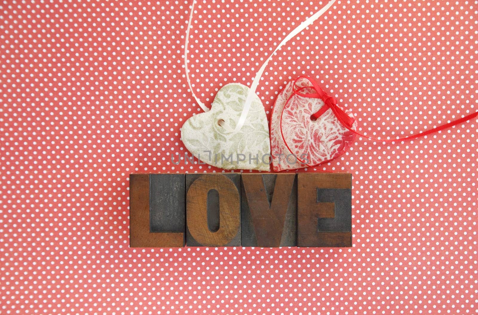 two salt dough ornaments with the word 'love' in old wood type on a polka dot background