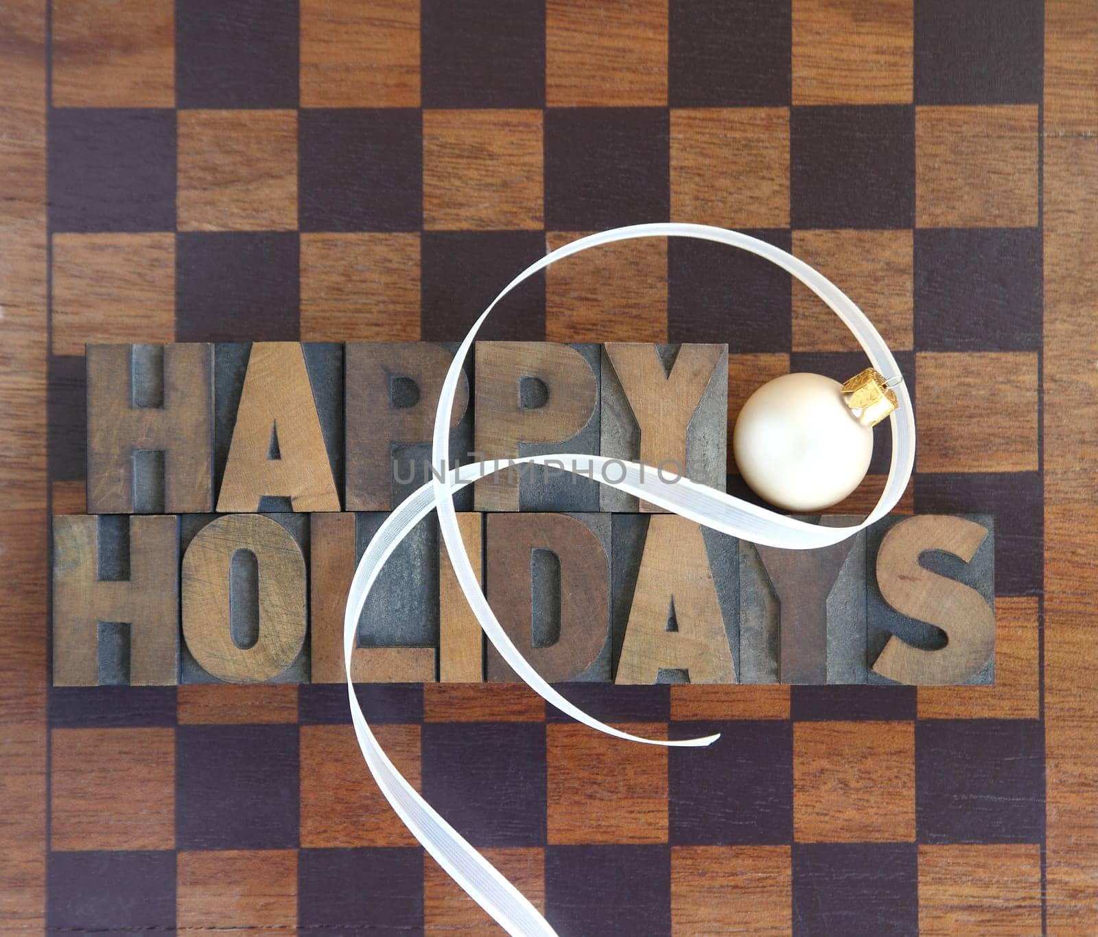 brown and black game board with the words 'Happy Holidays' and an ornament and ribbon