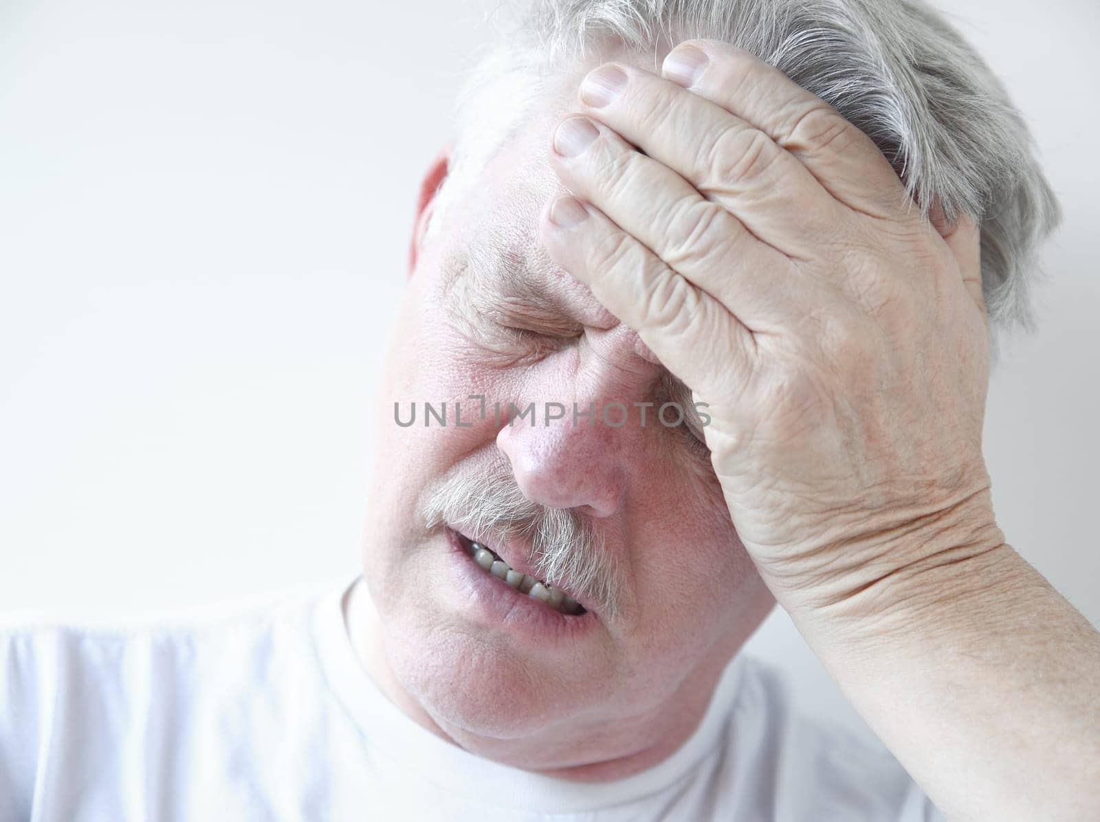 senior with hand on forehead and frown