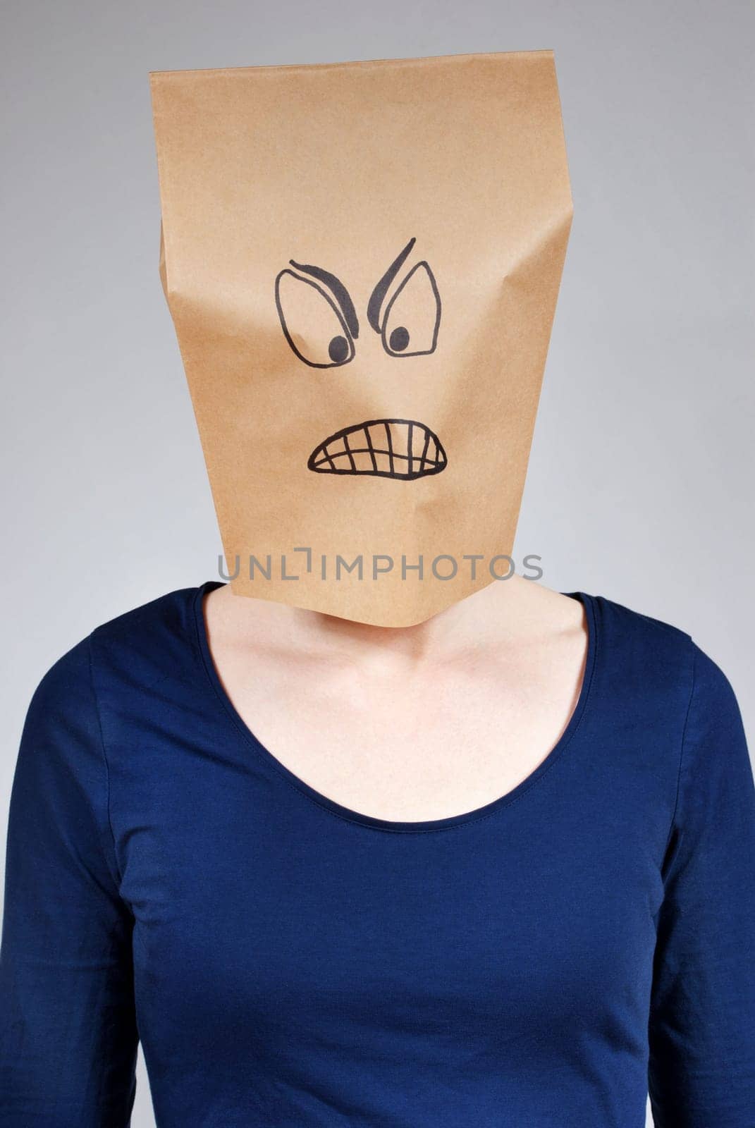 a mad looking person with paper bag head on a gray background