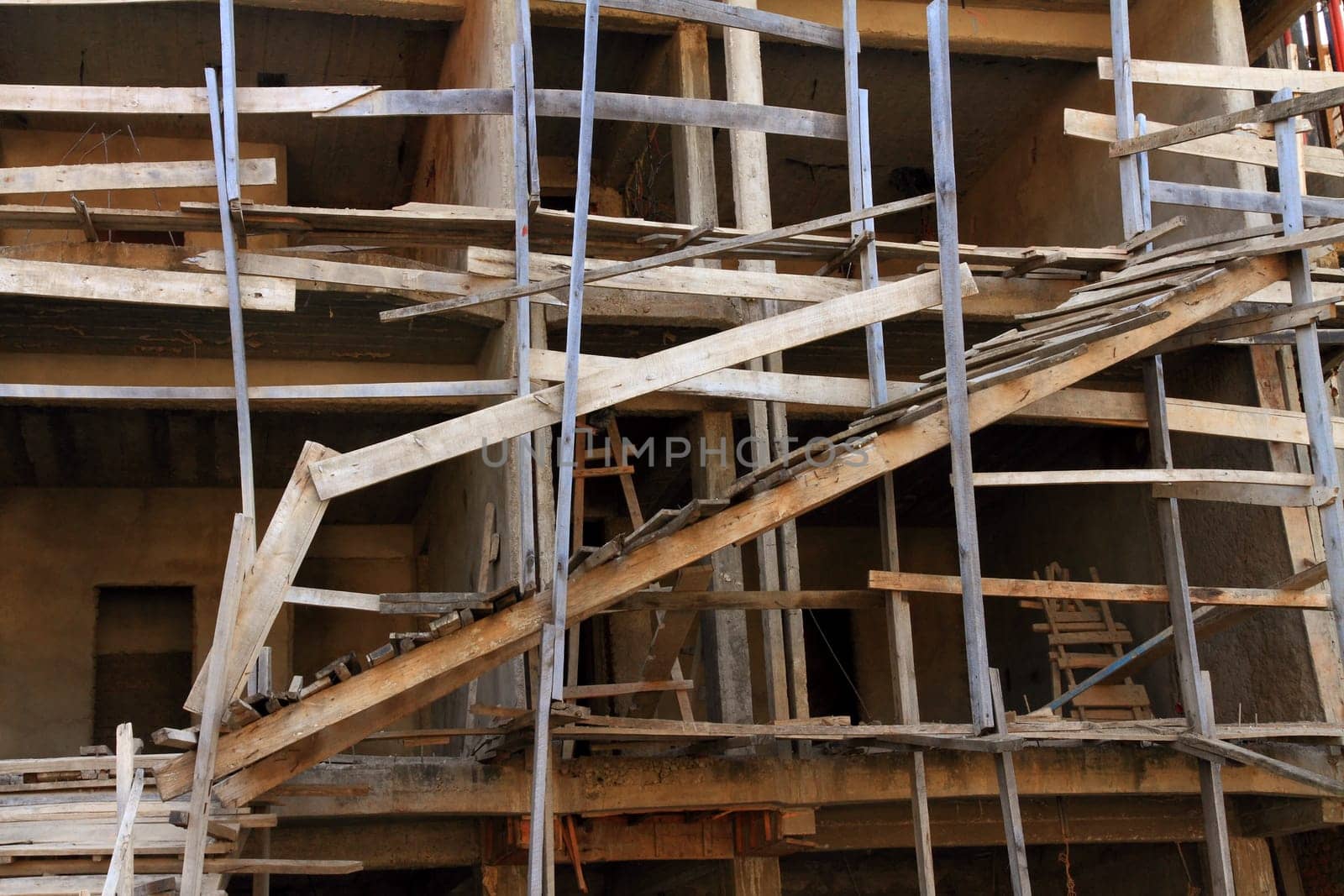 A very dangerous construction site with poorly constructed wooden scaffolding
