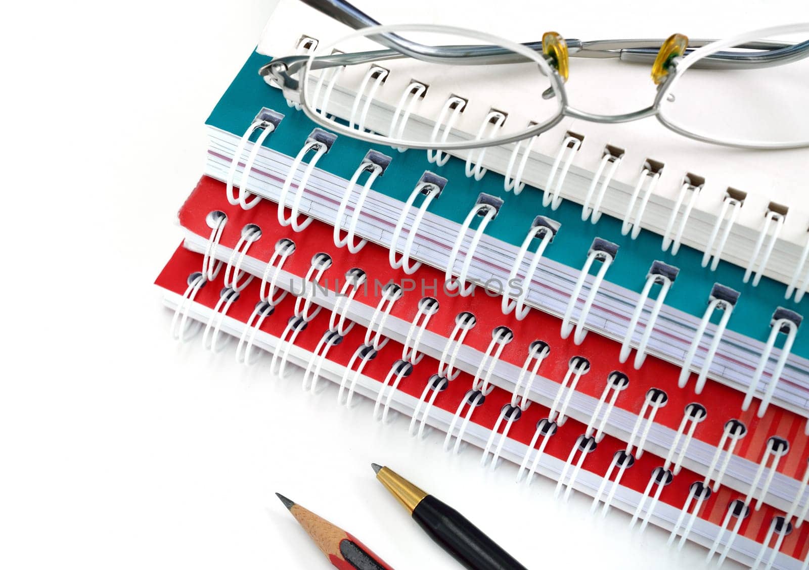 pencil,pen, notebook and glasses closeup, isolated on a white background