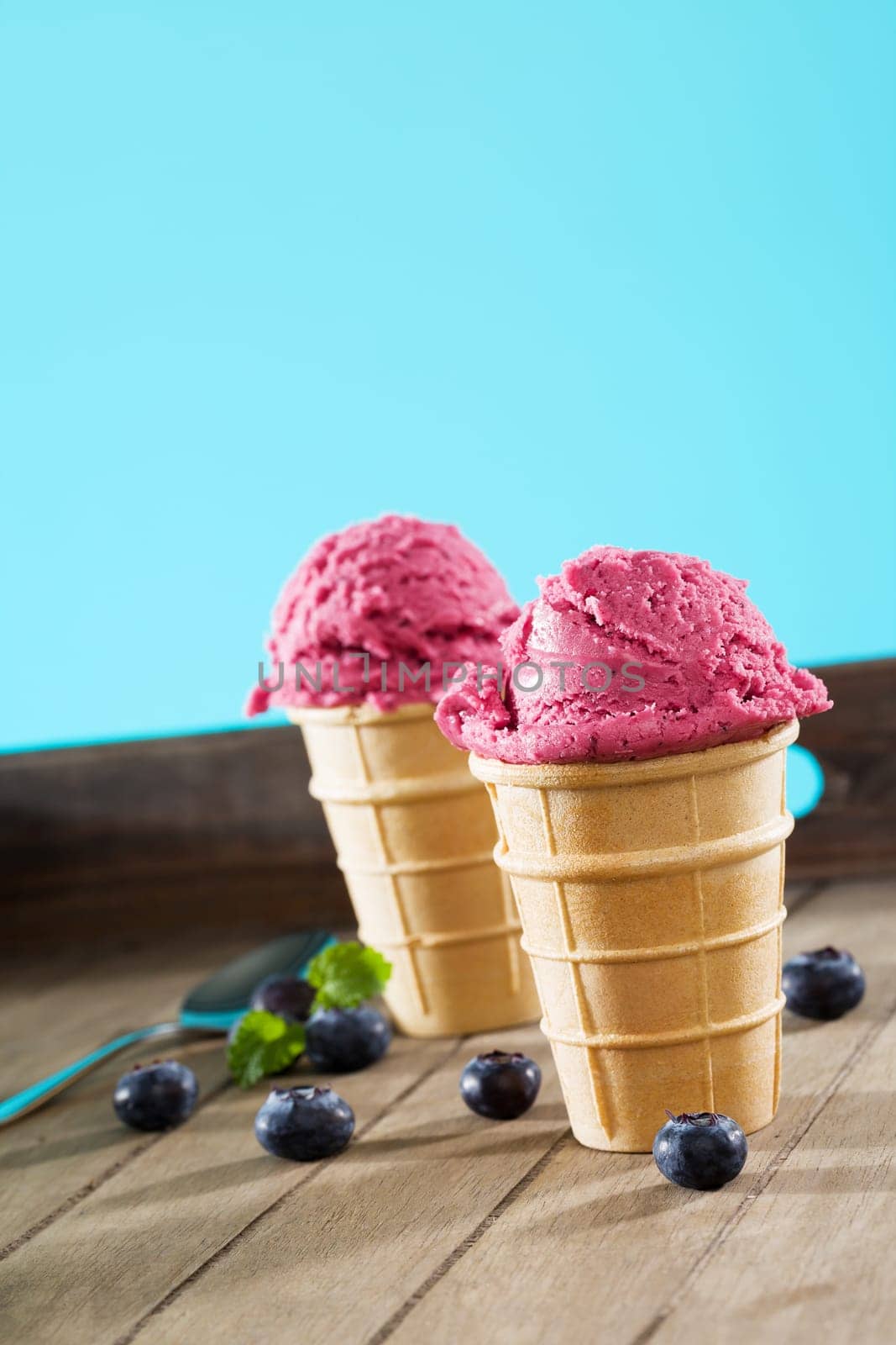 Blueberry ice cream in waffles with blueberries on wood