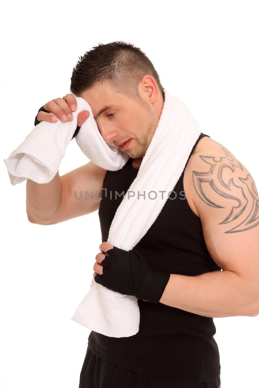 A young man stands there with a towel and seems to want to wipe off his sweat.