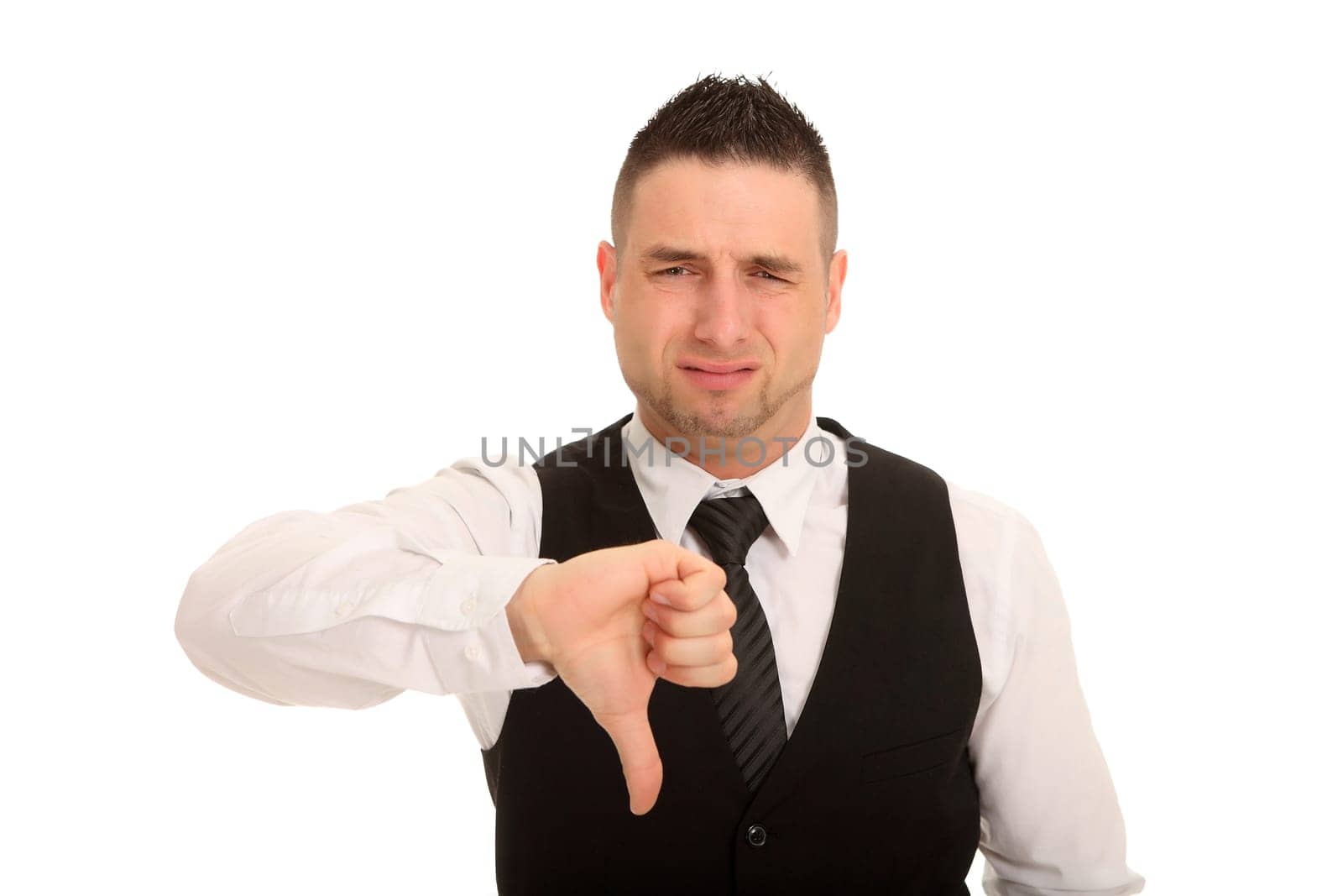 A young man points his thumb down and forgives his face in disappointment.