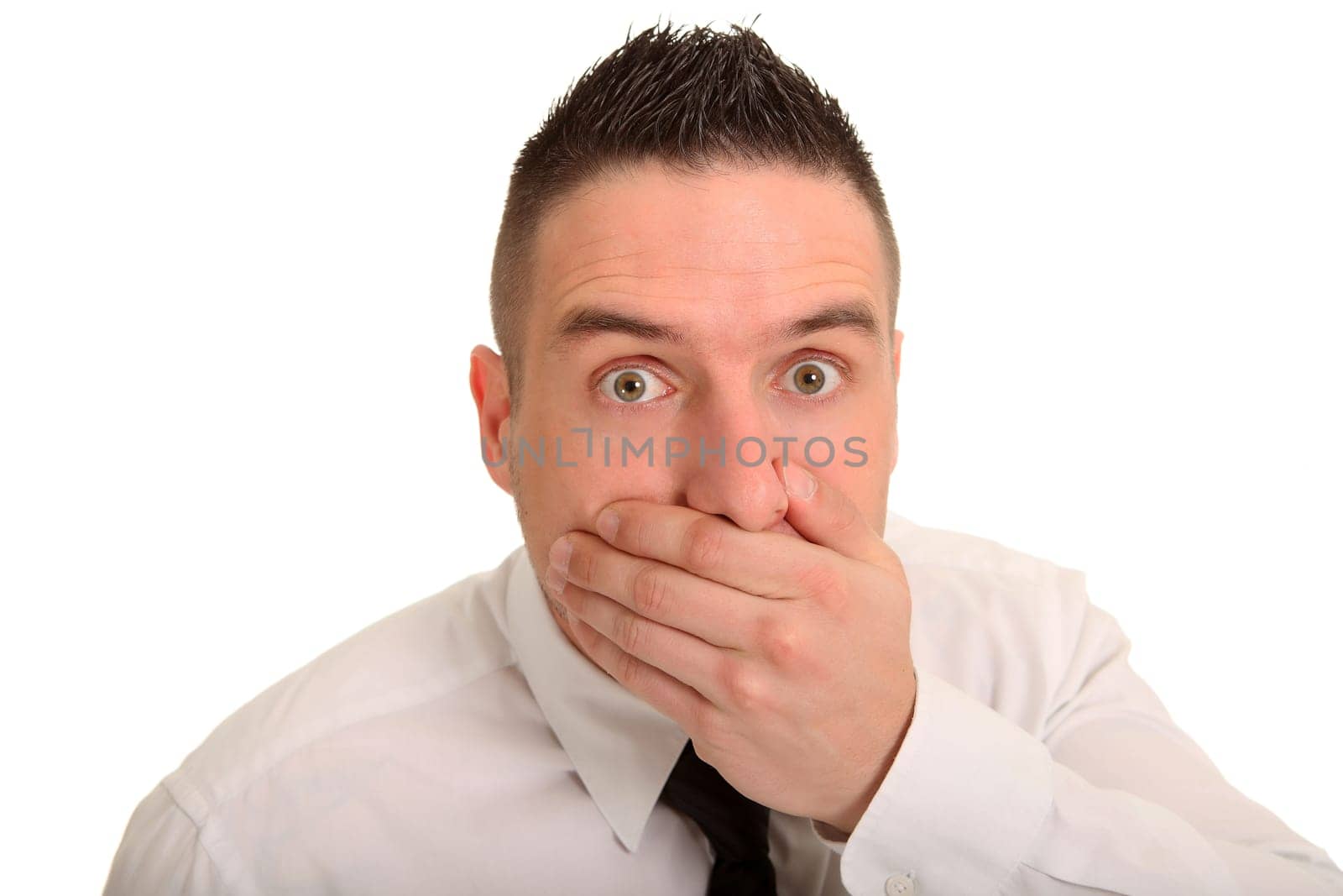 Portrait photo of a businessman who is frightened and holds his hand in front of his mouth and widens his eyes.