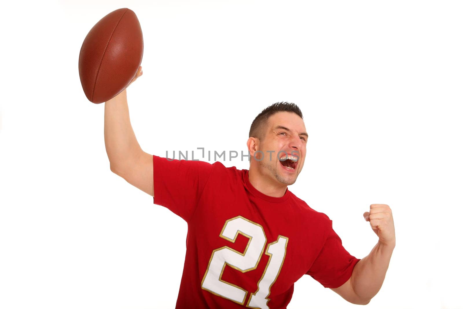 The photo shows a football player jubilantly holding up a ball,looking to the side.