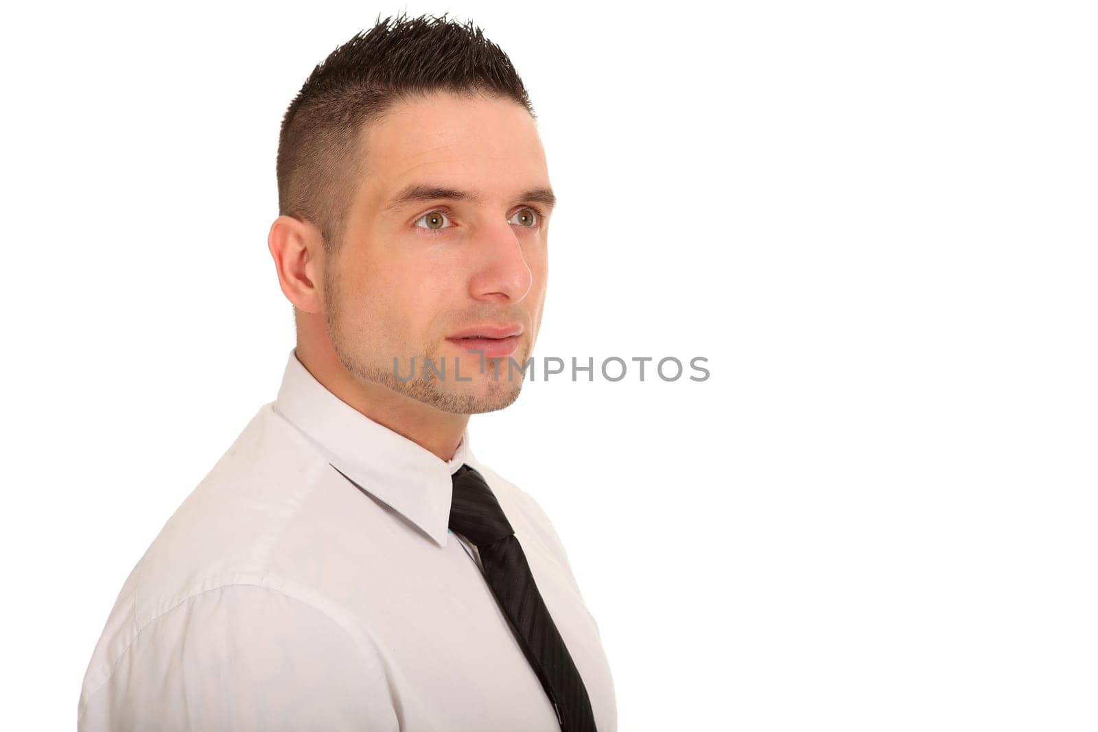 Portrait photo of a young businessman taken from the side. He looks into the distance.