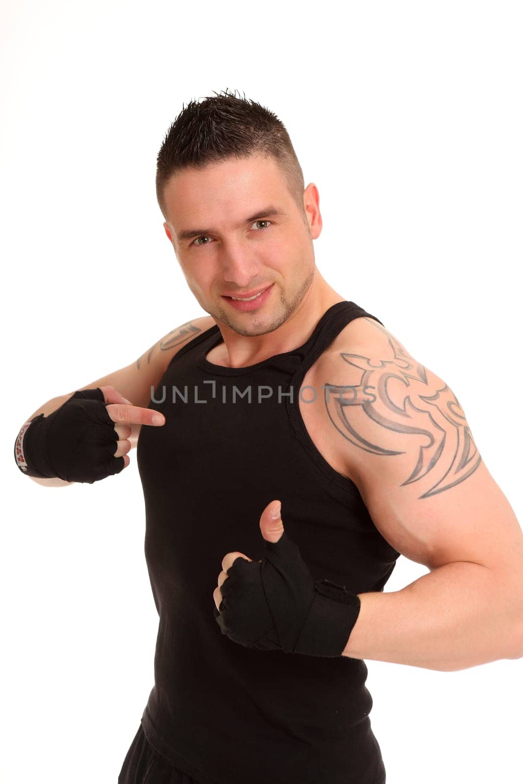 A young athlete stands there with his thumbs up and points directly at himself with his other hand.