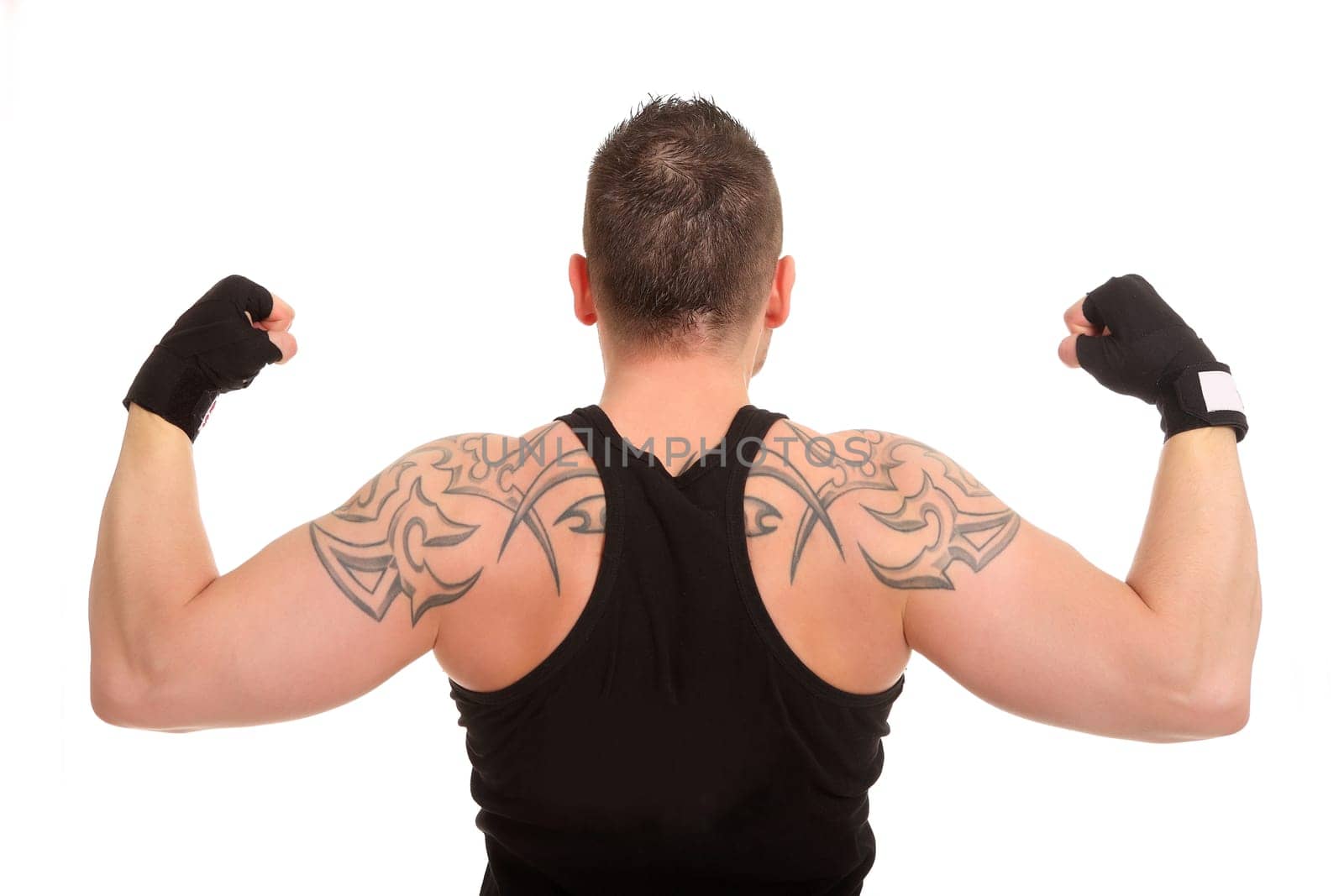 The photo shows a young man from the back who has tensed his muscles