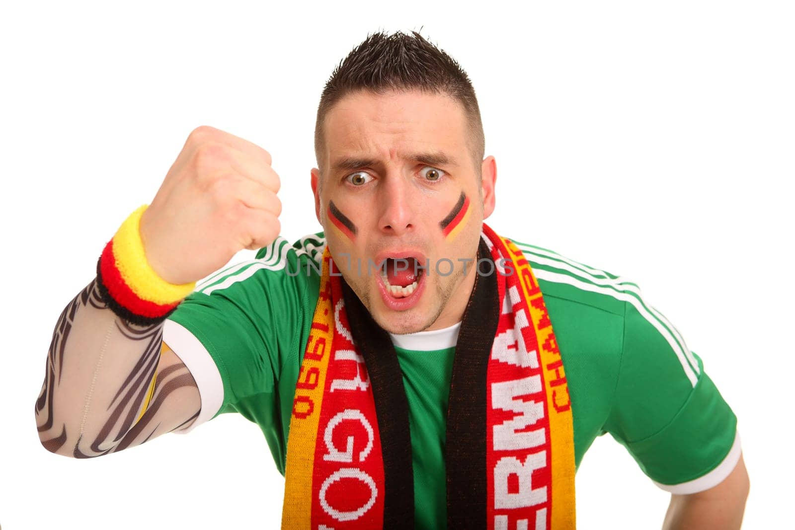 Portrait photo of a young man dressed as a fan. He has clenched his fist angrily and seems to be roaring downwards.