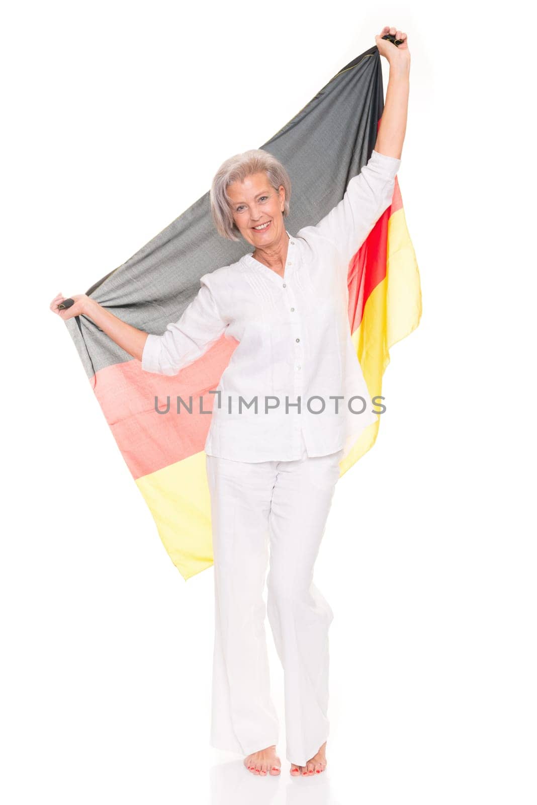 Senior woman as a German football fan in front of white background