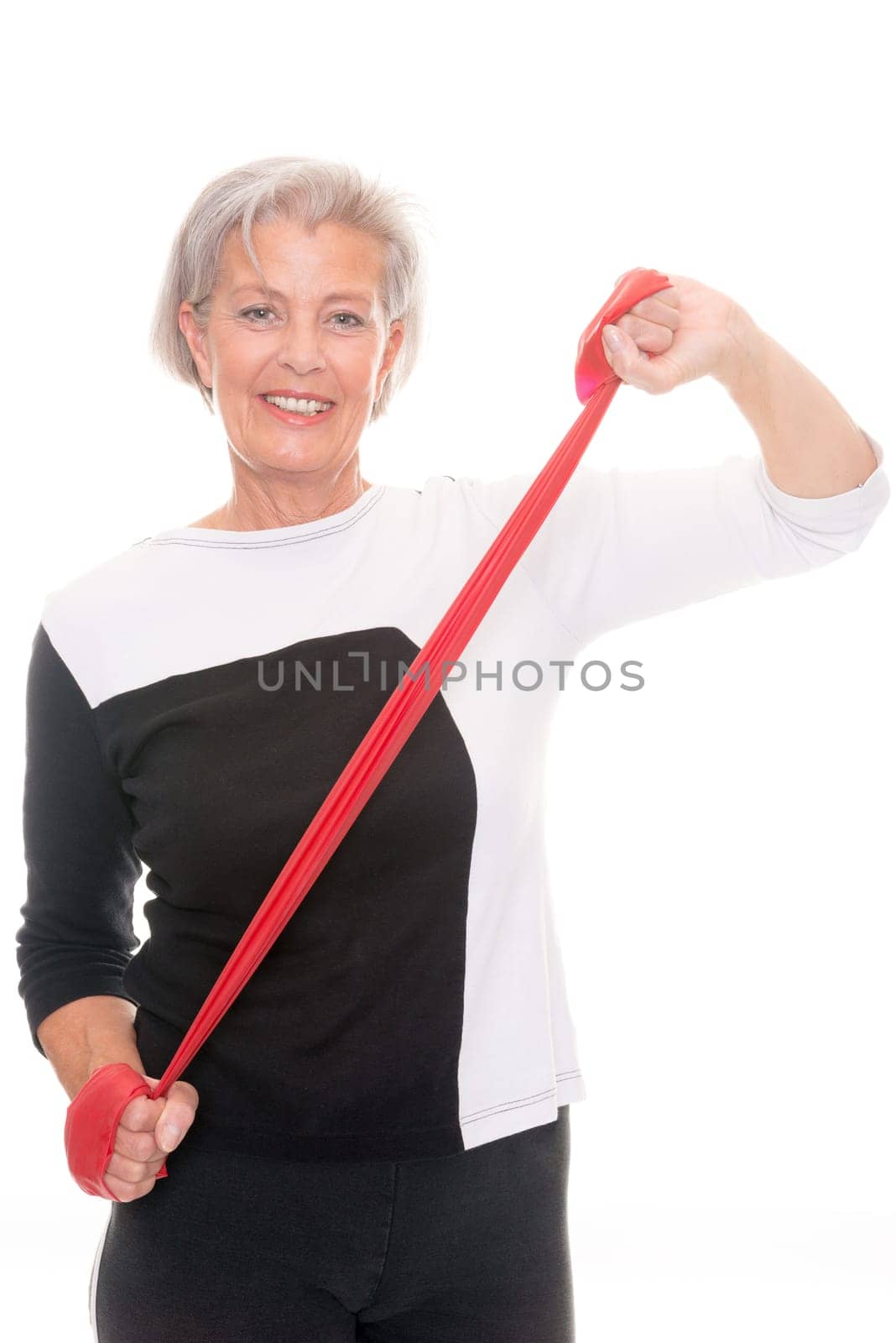 Active senior woman doing sports in front of white background