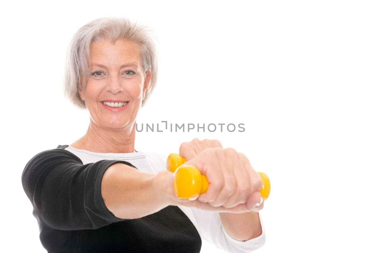 Active senior woman doing sports in front of white background