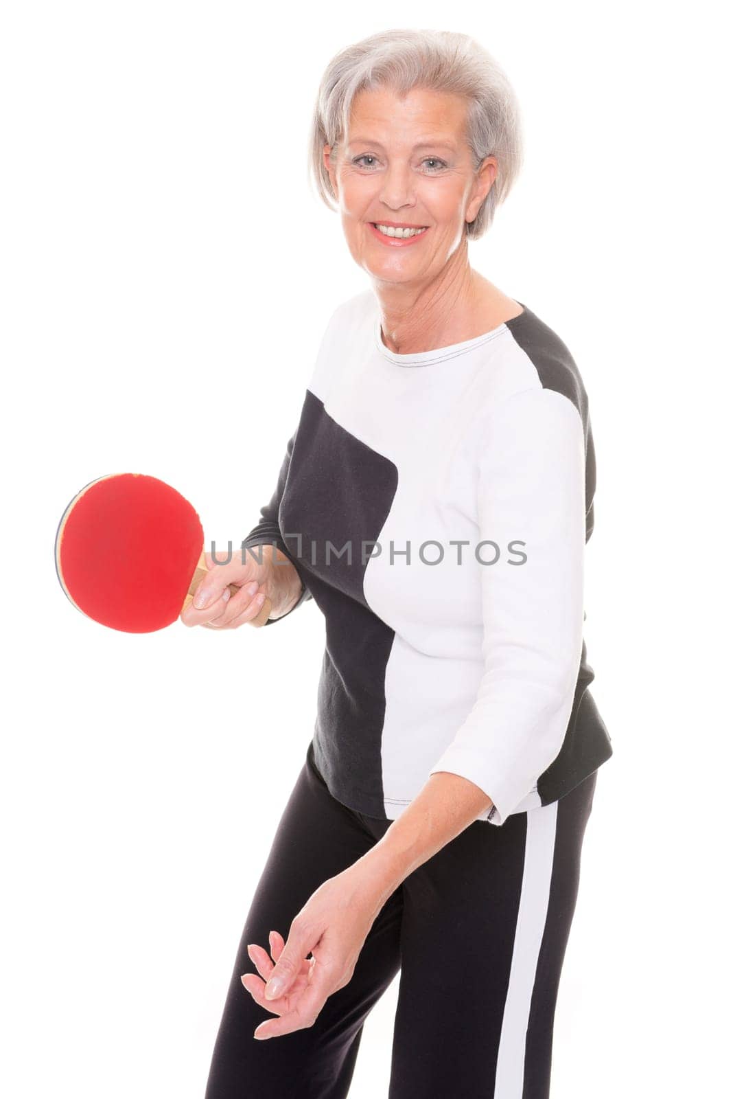 Active senior woman doing sports in front of white background
