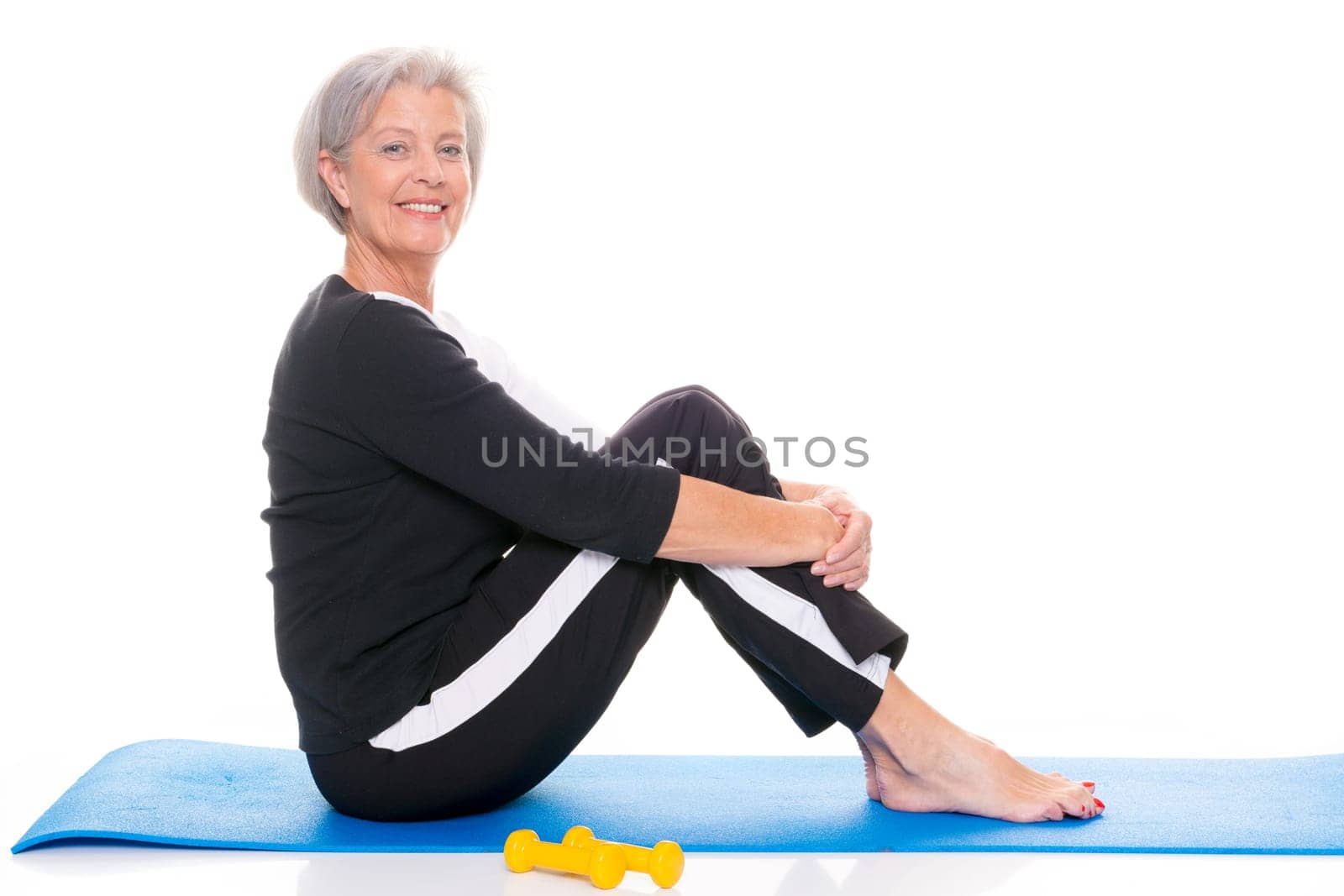 Active senior woman doing sports in front of white background
