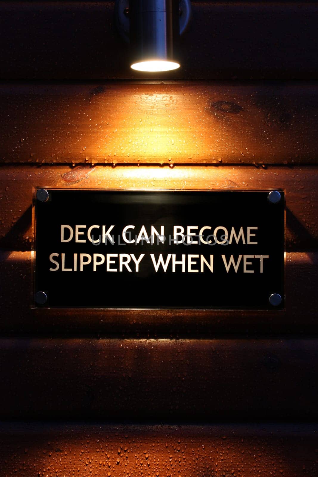 Lit warning sign on wet wood