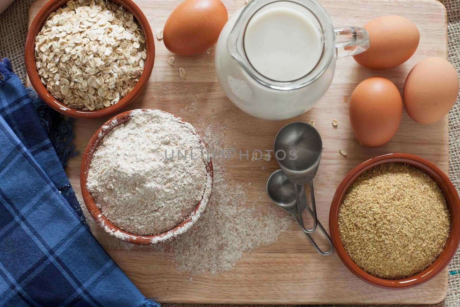 Ingredients for whole grain healthy bread, whole wheat flour, rolled oats and wheat germ with milk and eggs.