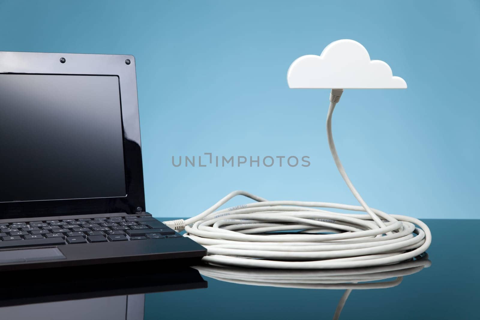 Cloud computing concept. Laptop connected to cloud via ethernet cable.