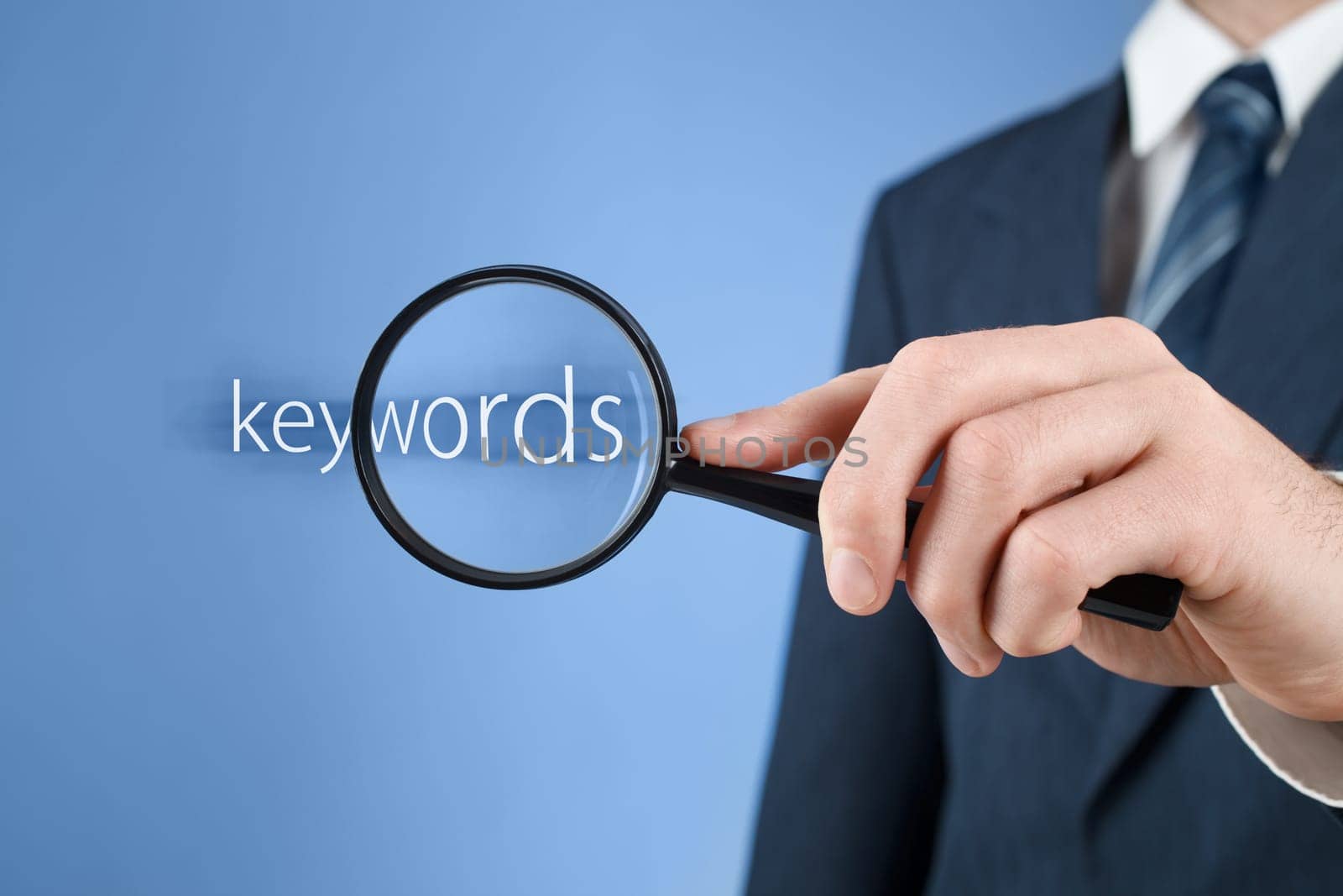 Keywords analysis, look for, search for and seek concept. Man with magnifying glass and text keywords.