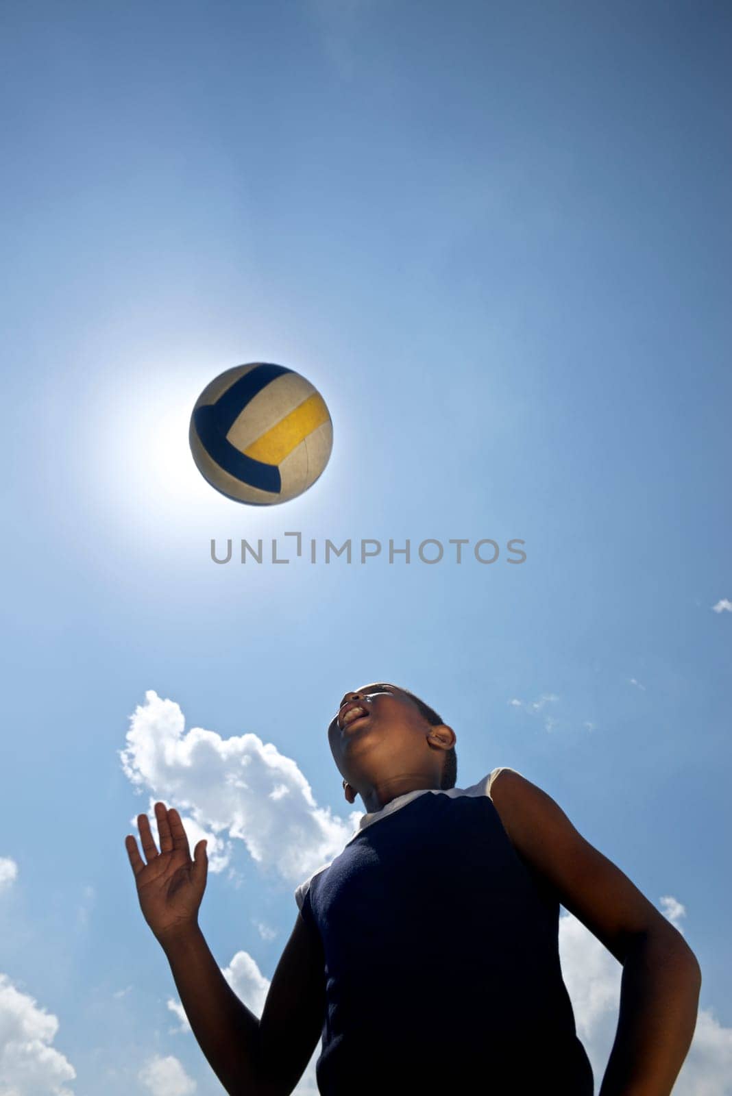 Kids playing football game, young child hitting soccer ball in park
