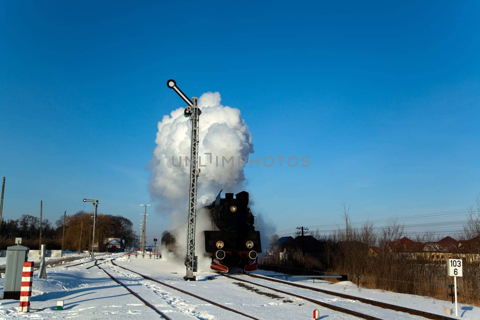 Vintage steam train puffing through countryside during wintertime