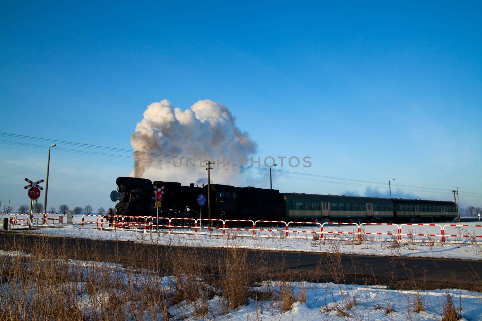 Vintage steam train puffing through countryside during wintertime