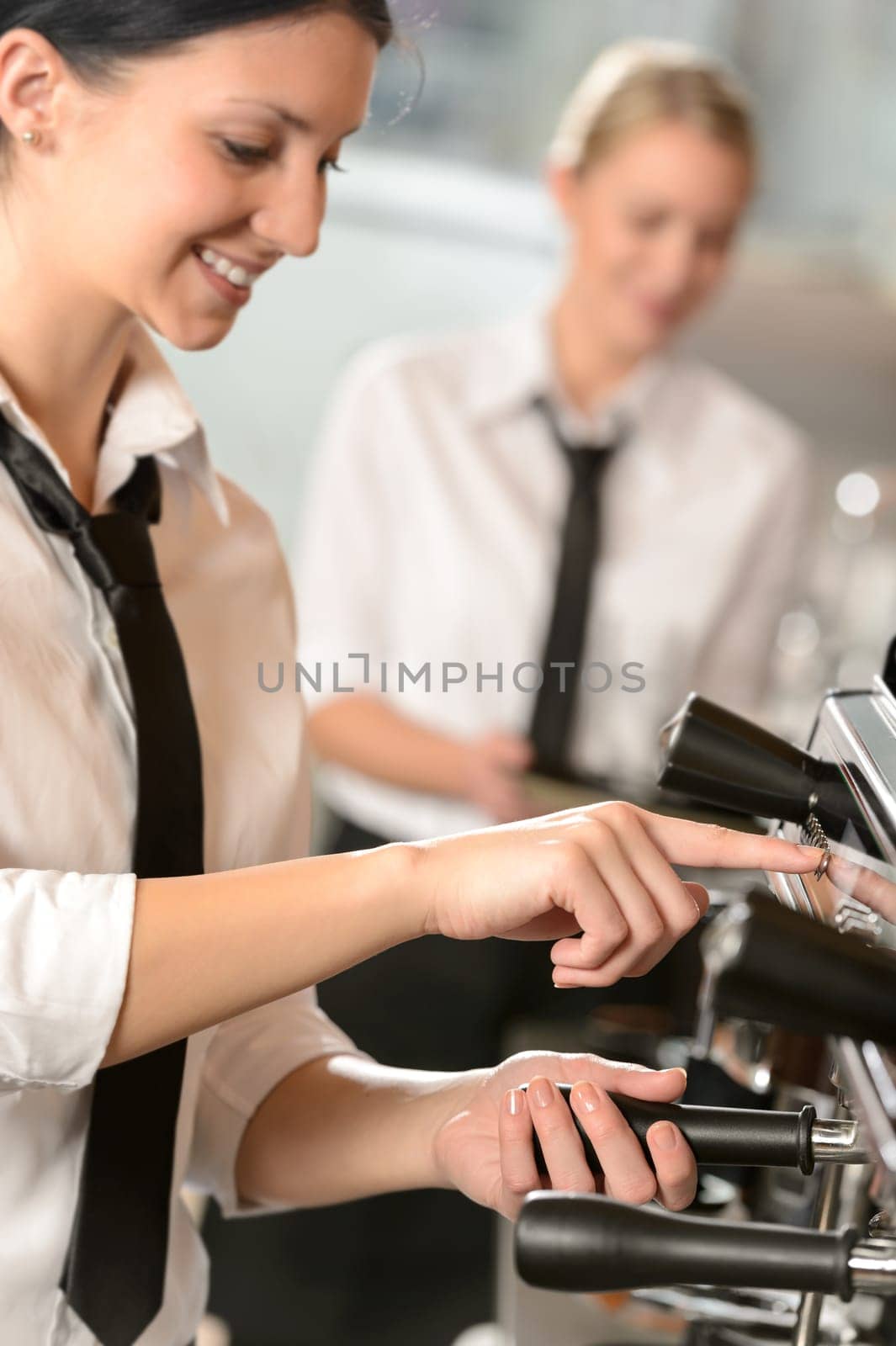 Smiling women waitress preparing coffee with machine