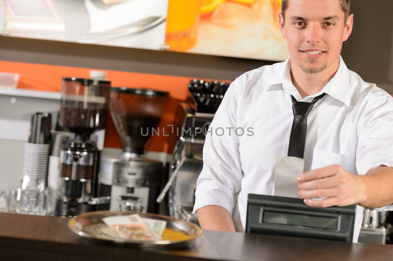 Handsome smiling male waiter giving receipt czech crowns in pub