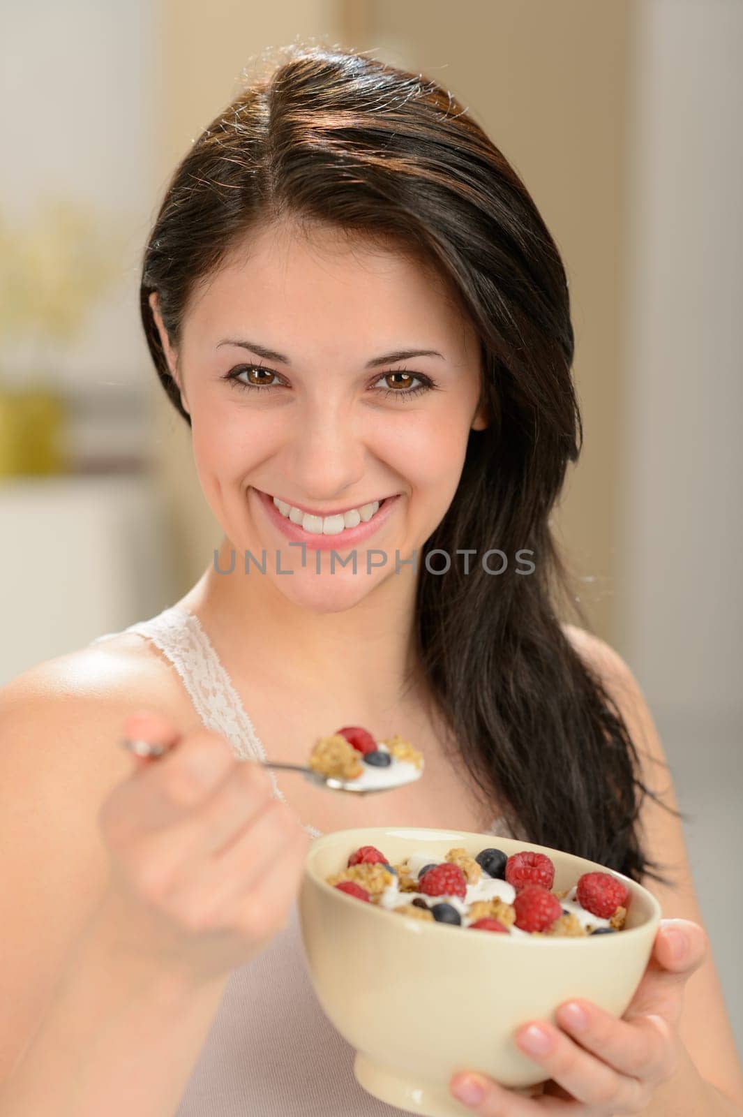 Attractive young woman eating a healthy bowl of cereal