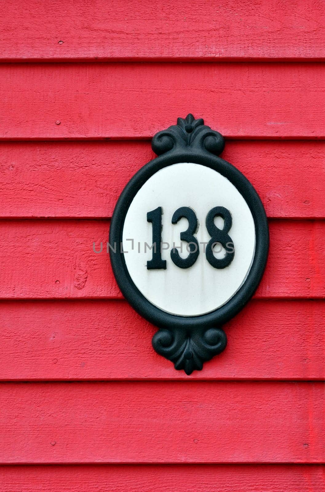 Old street number on wooden house front.