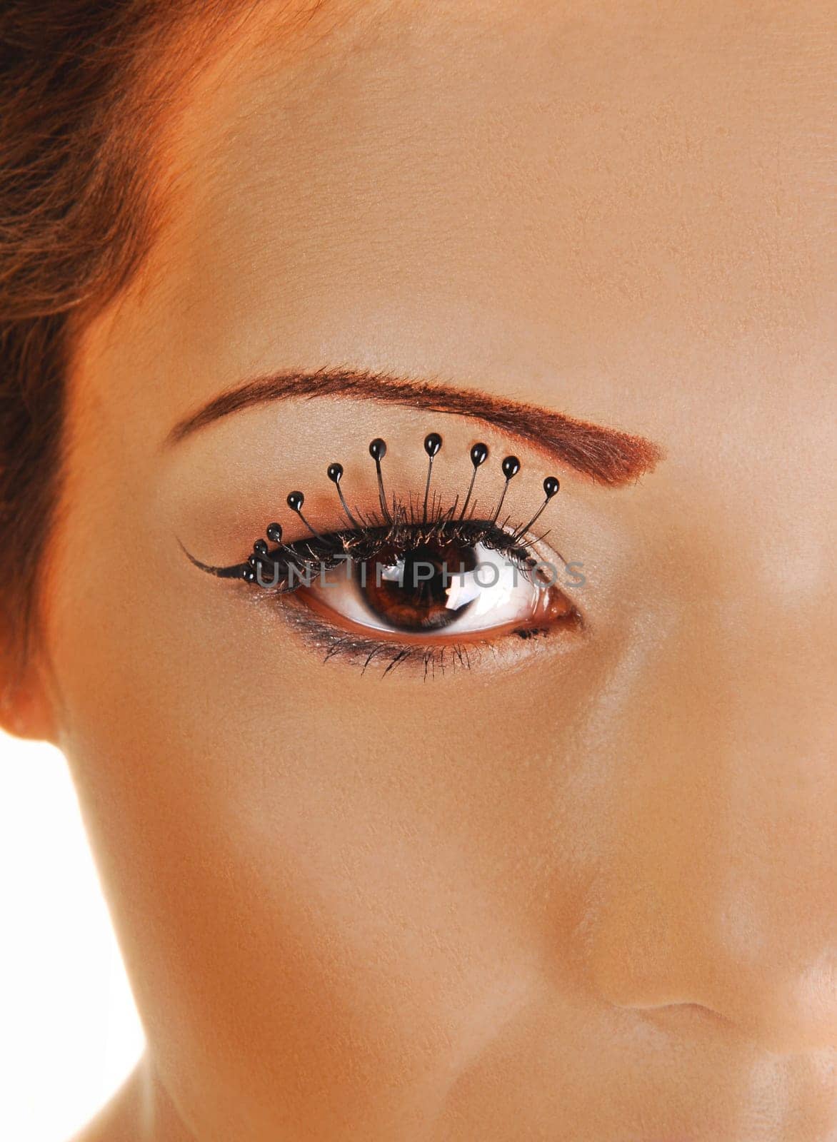 A closeup shoot if a woman's eye with long eyelashes, looking into the camera.