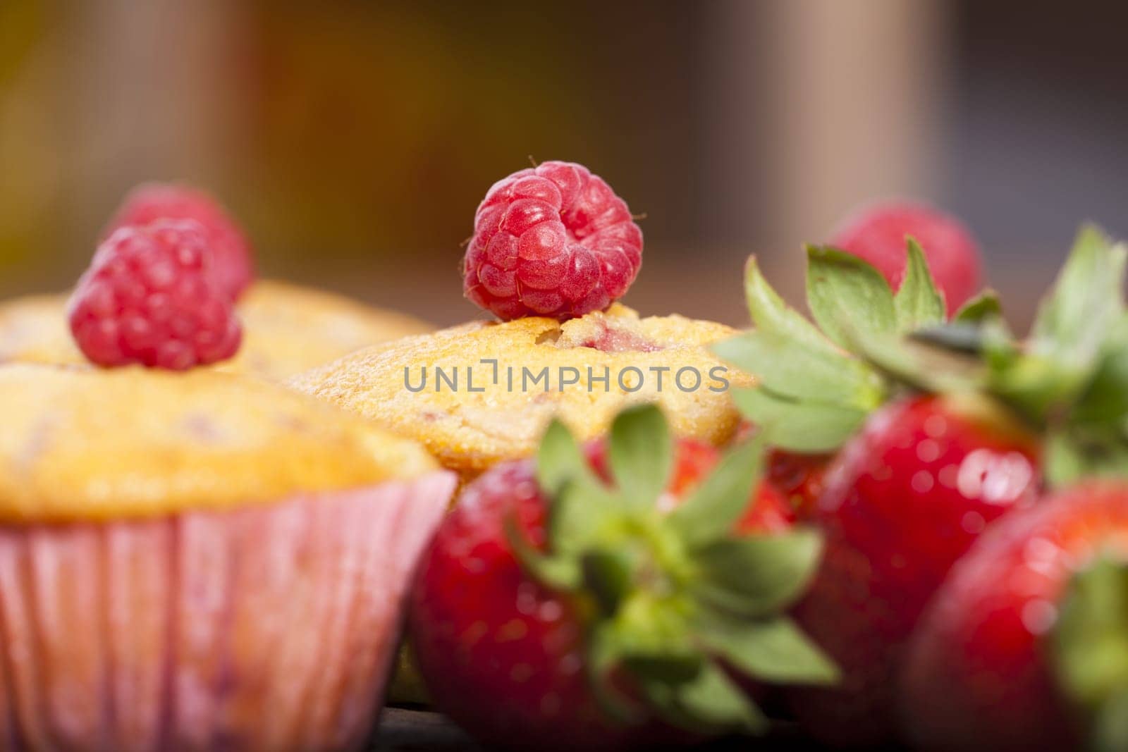 Close-up view of a strawberry-rhubarb-raspberry muffin with targeted blur