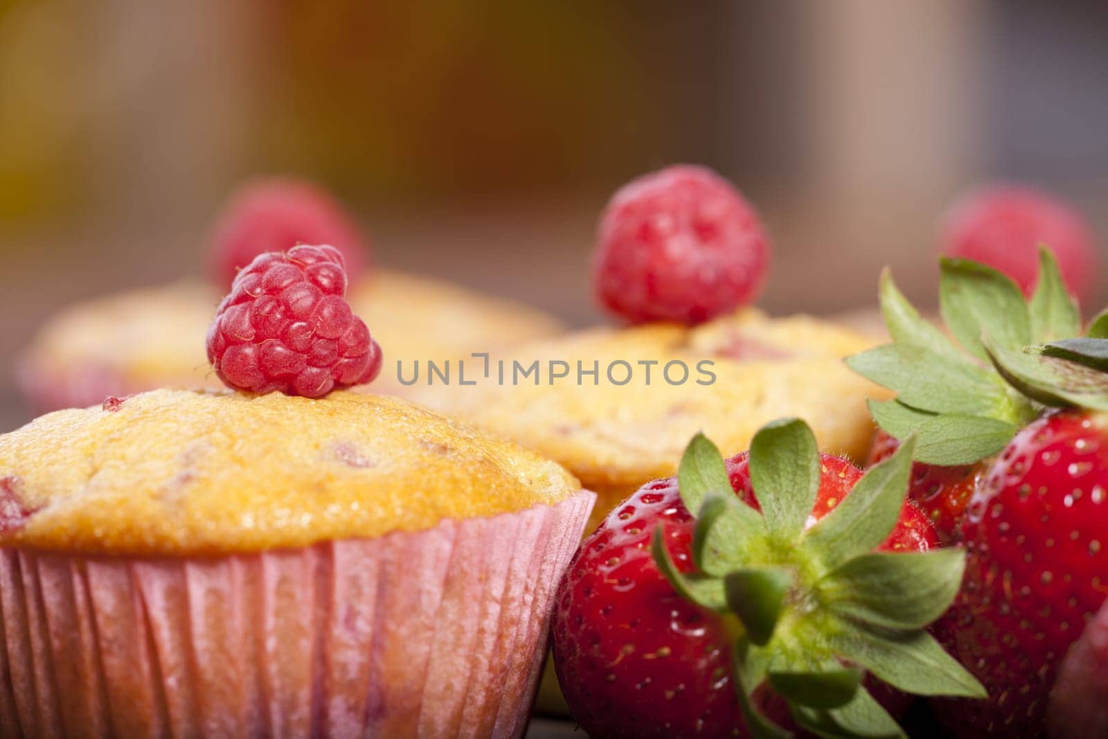 Close-up view of a strawberry-rhubarb-raspberry muffin with targeted blur