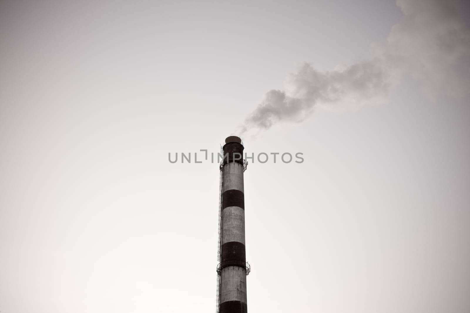 black and white old photo of the industrial pipe with smoke