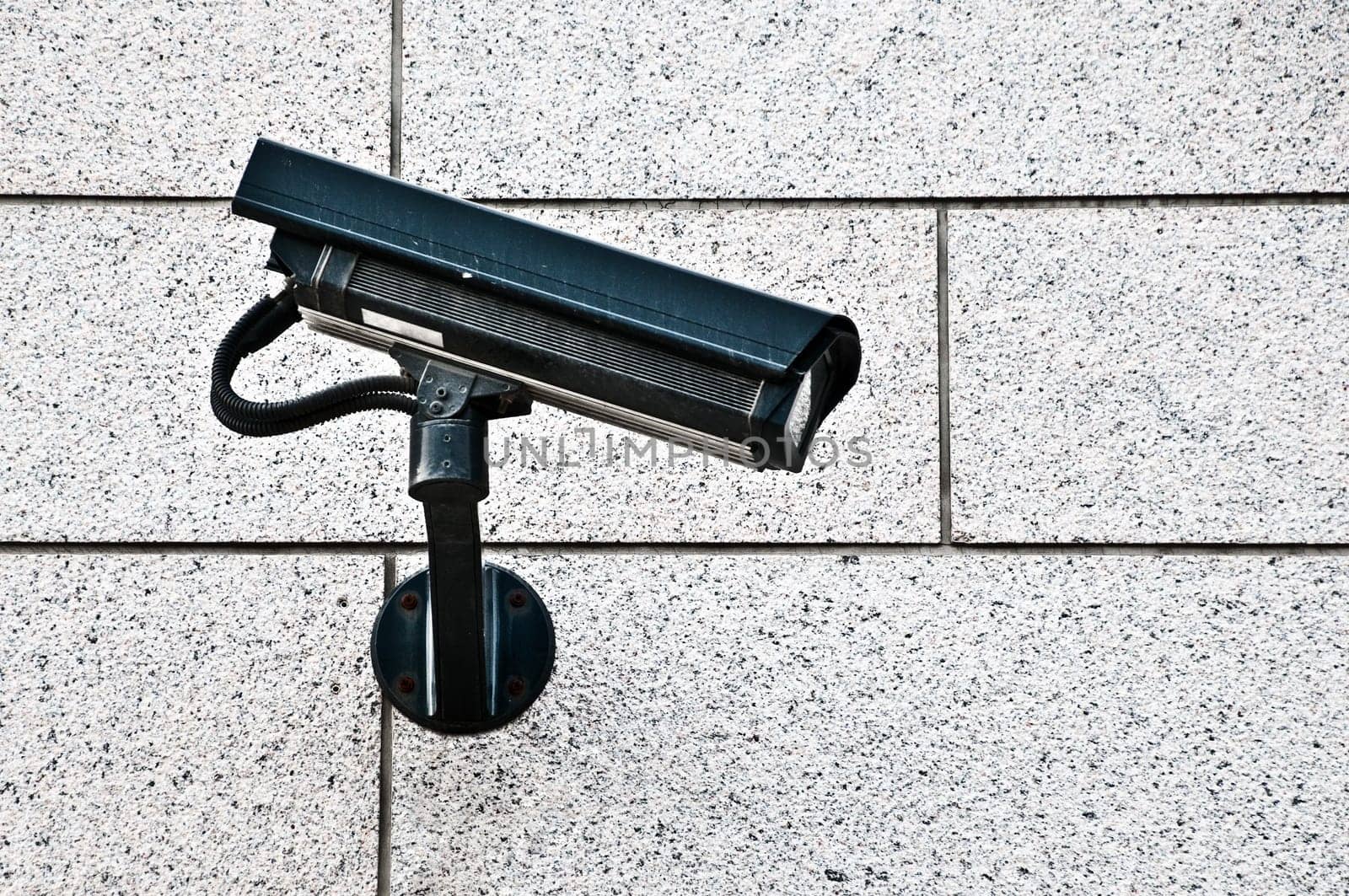 modern security camera on wall of building in street of city