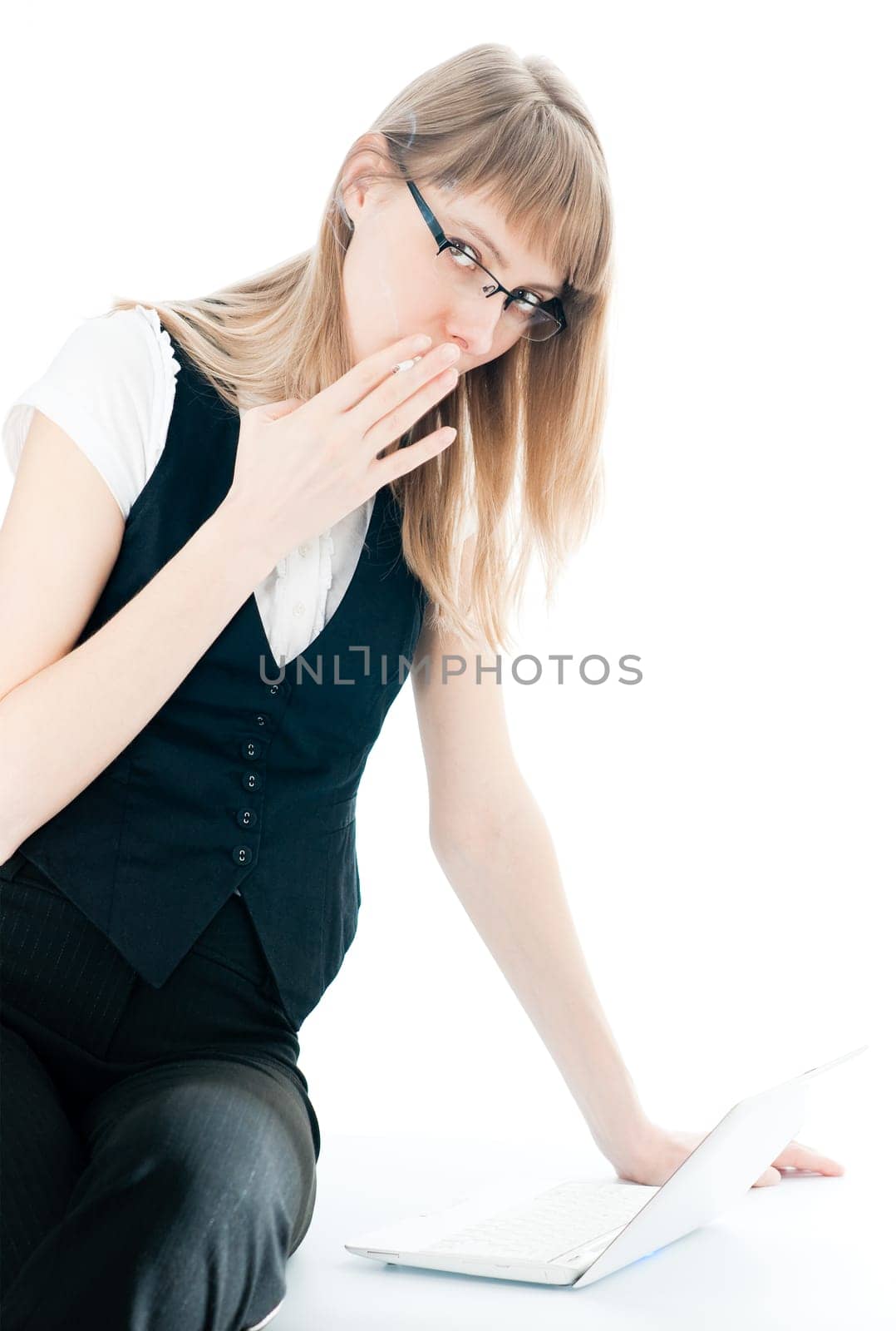 beautiful young business woman isolated on white sitting on the table with computer and smoking