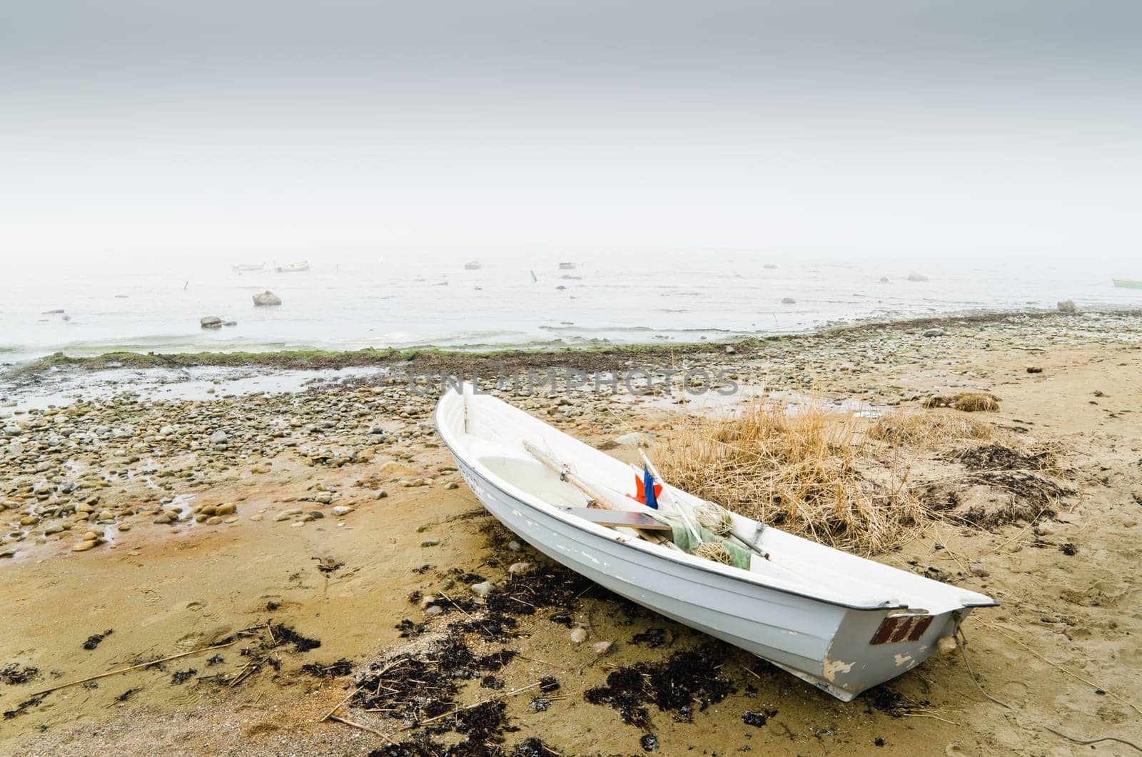 Old fishing boat at coast foggy in the morning