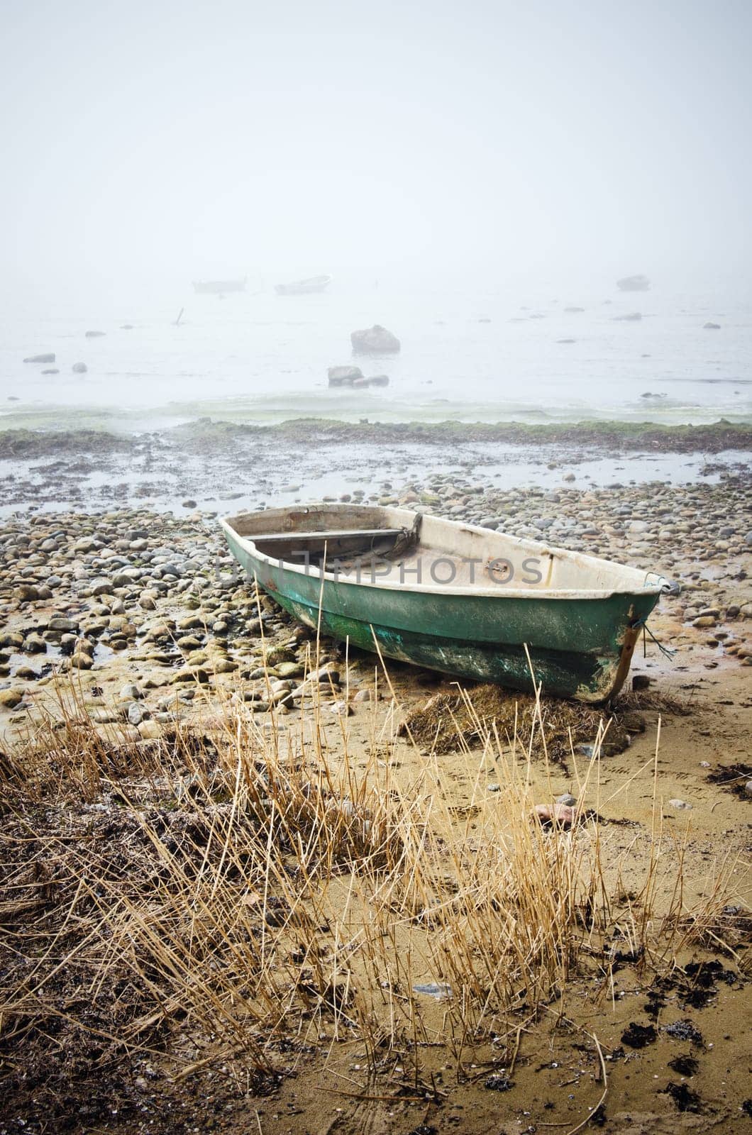 Old fishing boat at coast foggy in the morning