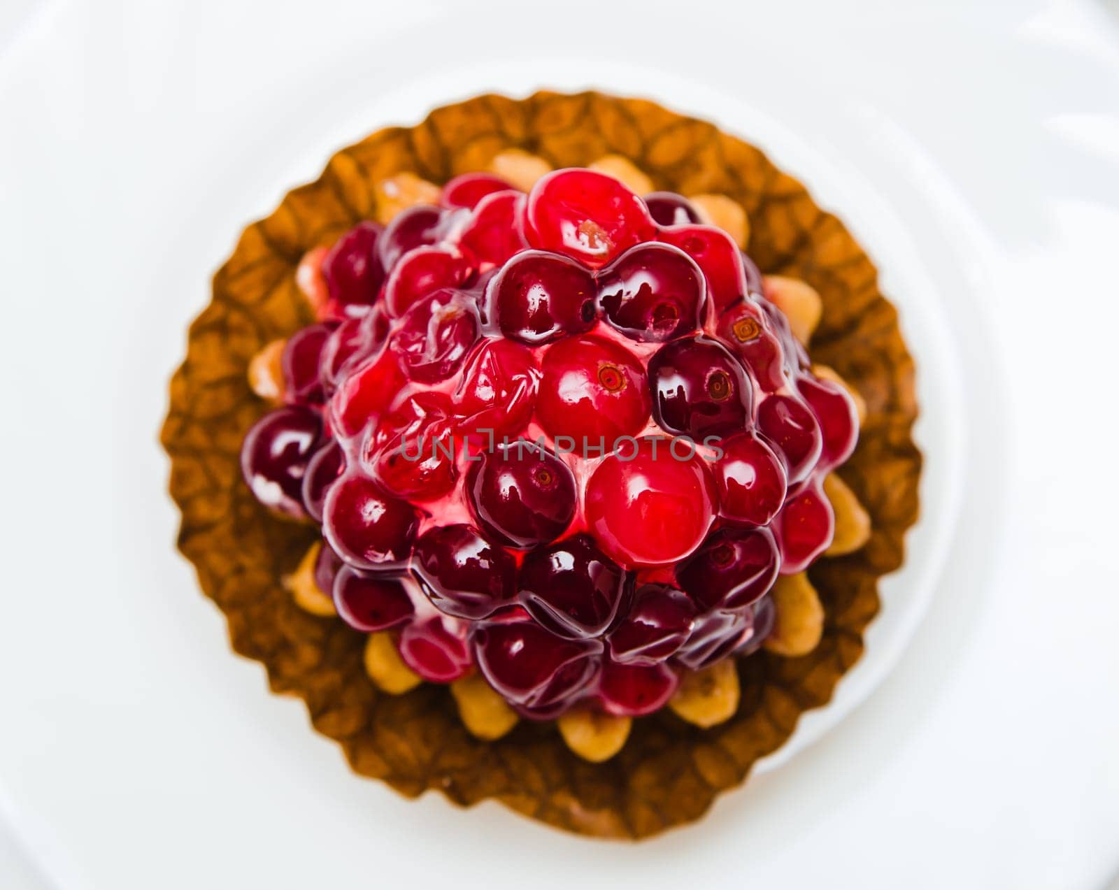 Cake with a cranberry on a white plate, a close up