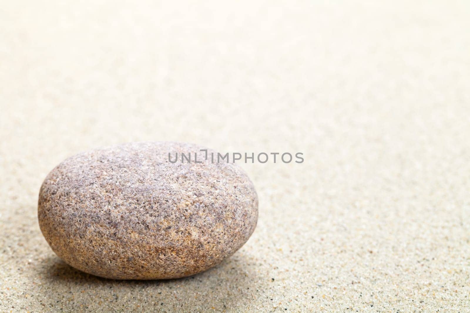 Beige stone in sand. Nature background with copy space. Macro shot
