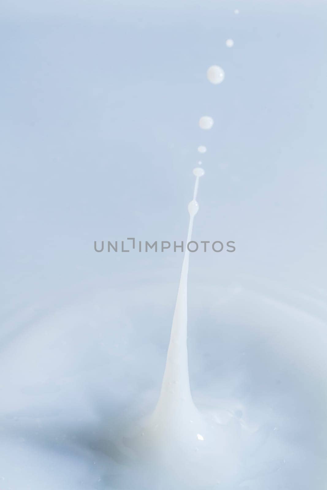 Close view of a droplet of milk hitting a surface of milk.