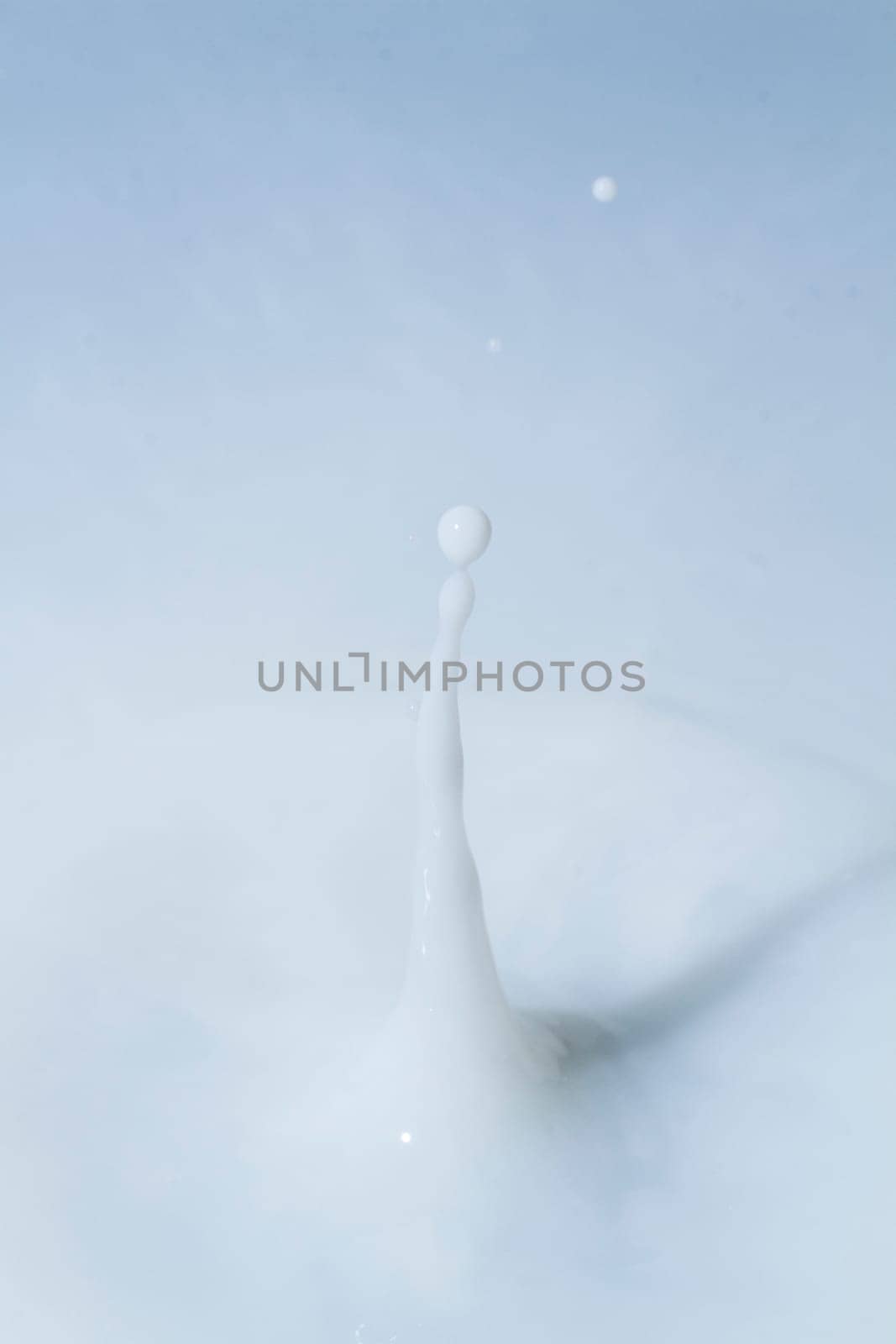 Close view of a droplet of milk hitting a surface of milk.