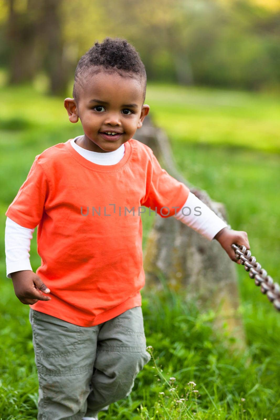 Outdoor portrait of a cute young  little black boy playing outside - African people