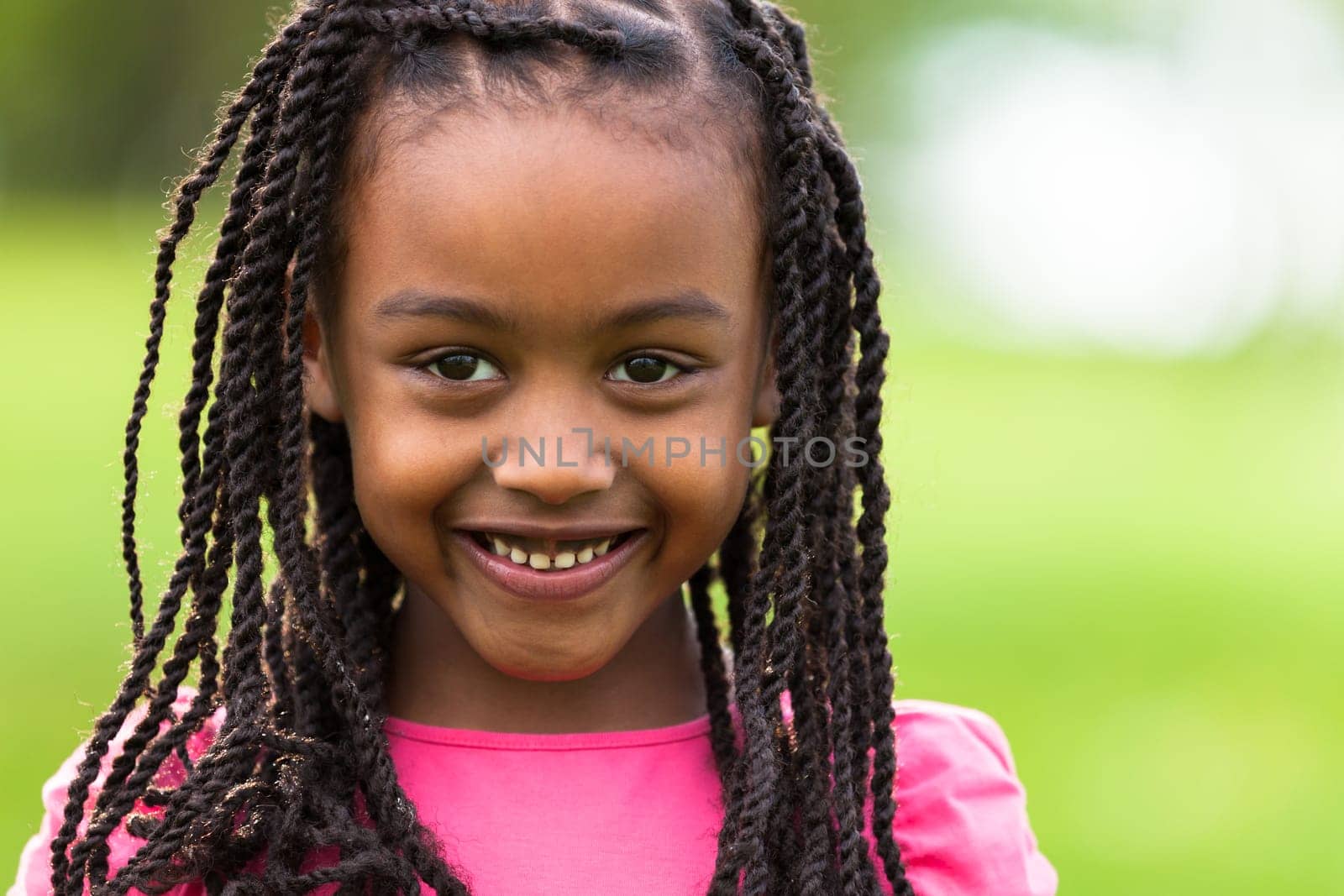 Outdoor close up portrait of a cute young black girl smiling - African people