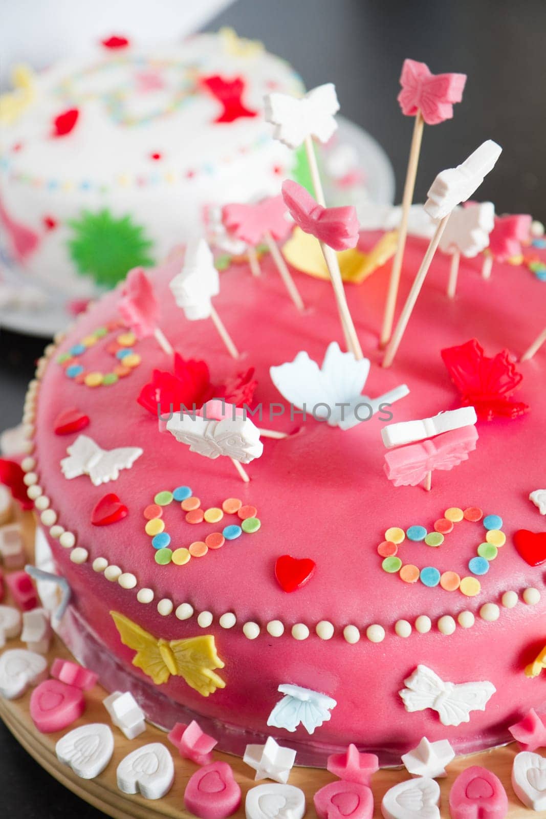 Colorful decorated white and pink Marzipan cakes for a birthday party on kitchen dresser - close up with shallow dof