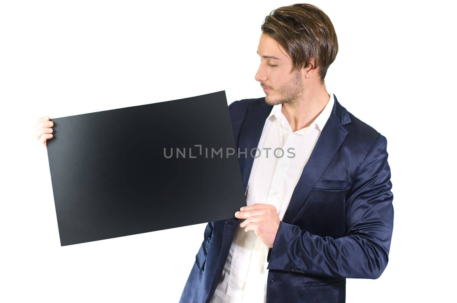 Attractive young man holding and showing empty, blank black board, sign or paper sheet