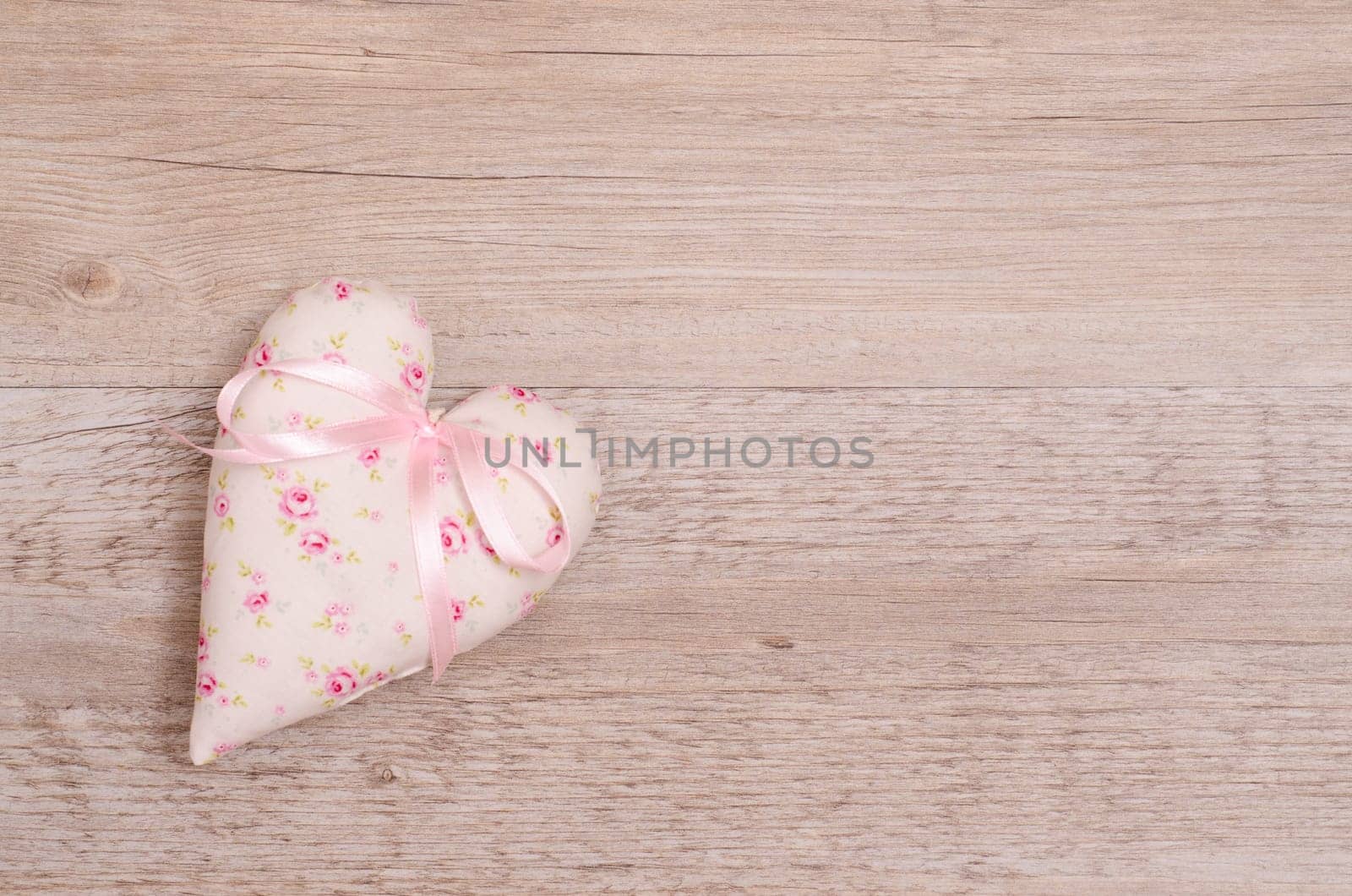 Heart with pink bow and text space on old wood