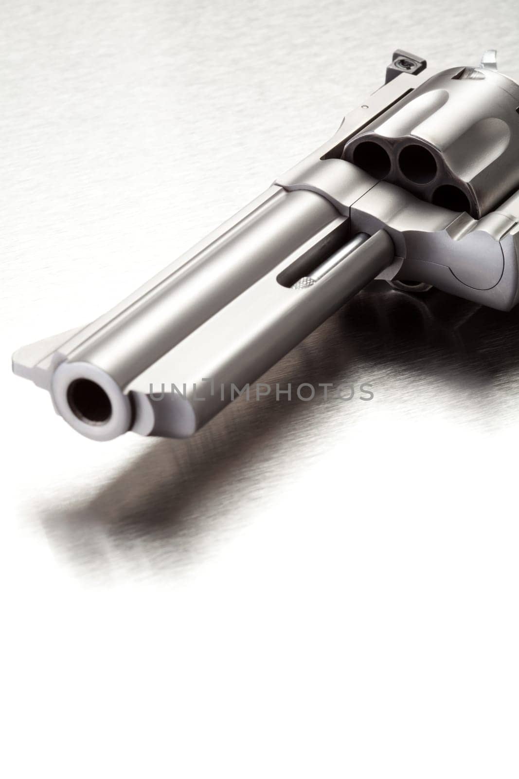 Gun on brushed metal surface - modern revolver with copyspace.